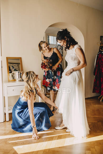 Amigos femininos felizes preparando noiva no quarto doméstico — Fotografia de Stock