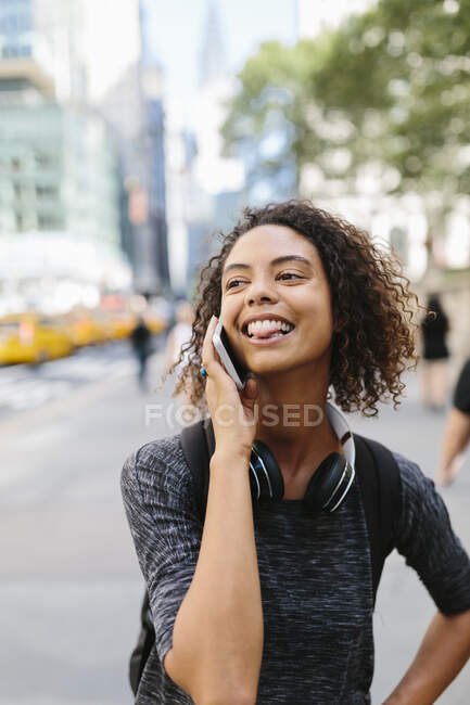 Молода жінка, розмовляючи на розумному телефоні в місті. — стокове фото