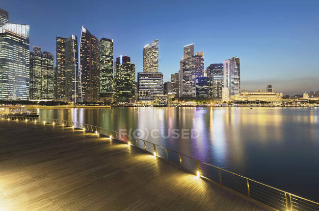Singapur, Langzeitbelichtung der Marina Bay in der Abenddämmerung mit Wolkenkratzern im Hintergrund — Stockfoto