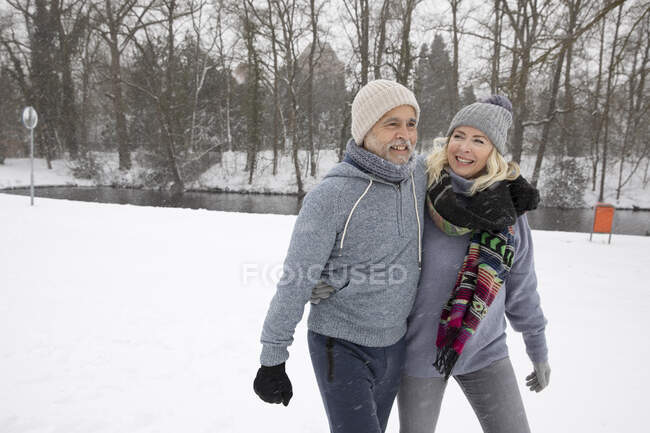 Homme âgé avec bras autour de la femme marchant dans le parc — Photo de stock