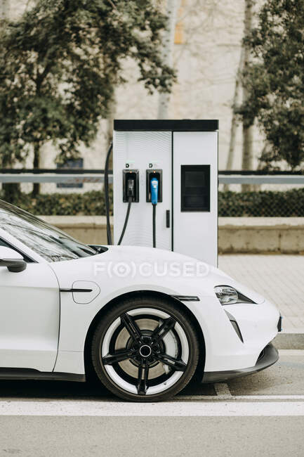Electric car charging at station on city street — Stock Photo