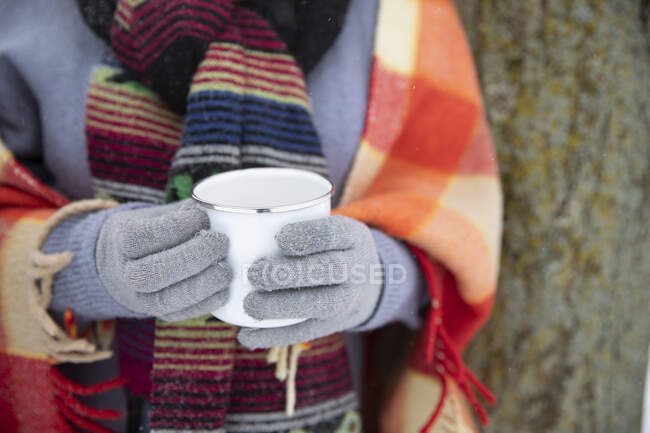 Woman wearing gloves while holding mug during winter — Stock Photo