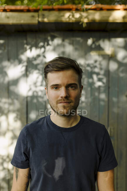 Mittlerer erwachsener Mann mit leerem Gesichtsausdruck vor Haus im Hinterhof — Stockfoto