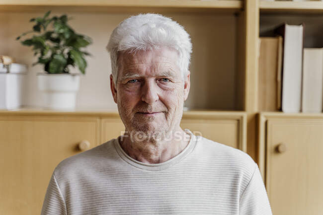 Hombre mayor sonriendo en casa - foto de stock