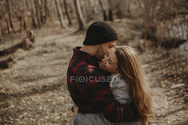 Felice coppia di metà adulto che abbraccia nella foresta — Foto stock
