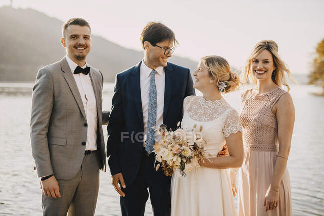 Sposi sorridenti con gli ospiti durante la cerimonia nuziale — Foto stock