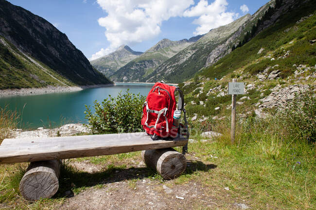 Backpack on wooden bench during sunny day at Zillertal, Austria — Stock Photo