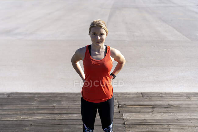 Jogger femminile in piedi sul molo durante la giornata di sole — Foto stock