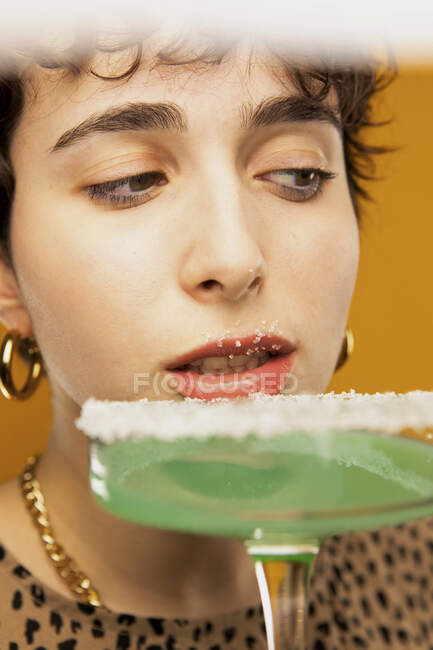 Женщина ест сахар на коктейльном бокале — стоковое фото