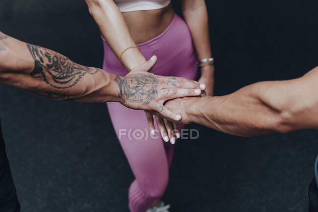 Sportswoman main empilée avec des amis dans la salle de gym — Photo de stock