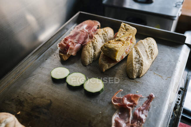 Bread with ham and veggies cooking on griddle at restaurant — Stock Photo