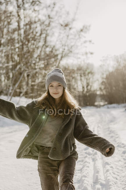 Retrato de bela menina adolescente caminhando através da neve em direção à câmera — Fotografia de Stock
