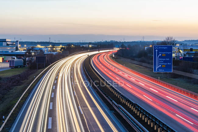 Deutschland, Baden-Württemberg, Fahrzeugampeln auf der A81 in der Abenddämmerung — Stockfoto
