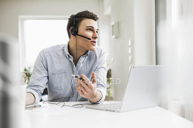 Imprenditore maschio discutendo in videochiamata attraverso il computer portatile durante la riunione a casa ufficio — Foto stock