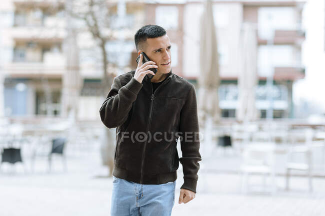 Geschäftsmann telefoniert mit Smartphone, während er gegen Gebäude läuft — Stockfoto