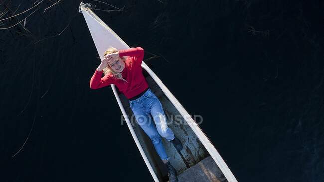 Mulher despreocupada sorrindo enquanto descansa em canoa no rio — Fotografia de Stock