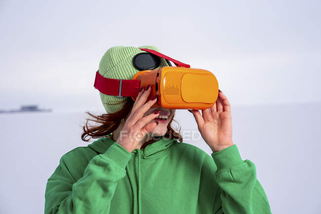 Woman in costume watching video through virtual reality simulator against sky — Stock Photo