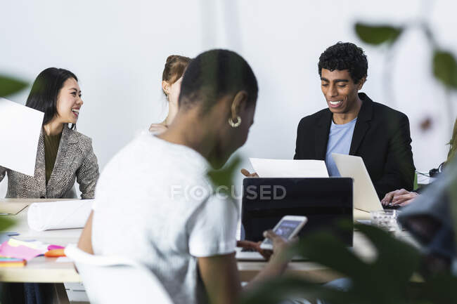 Lächelnde Geschäftsleute bei Meetings am Arbeitsplatz — Stockfoto