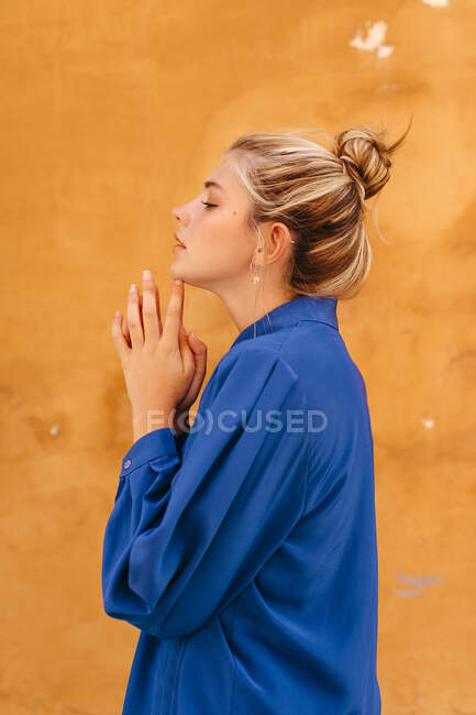 Woman with hair bun against yellow wall — Stock Photo