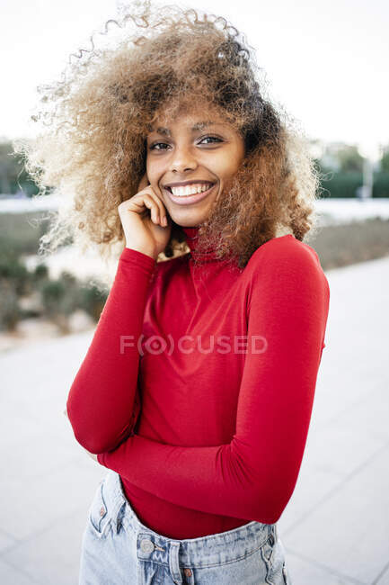 Усміхнена африканка стоїть з кучерявим волоссям — стокове фото
