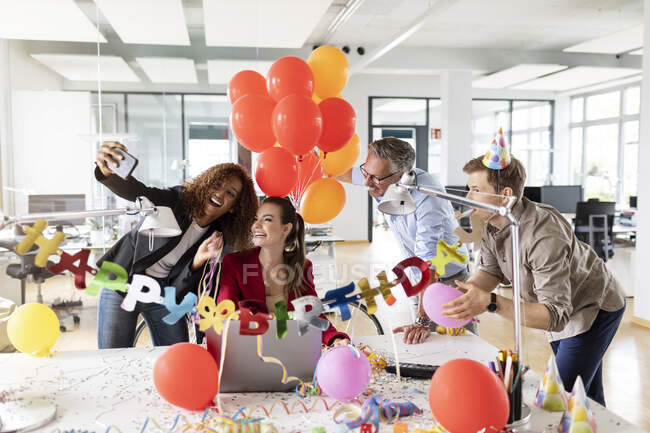 Fröhliche Geschäftsfrau macht Selfie mit Kollegen während der Geburtstagsfeier im Büro — Stockfoto