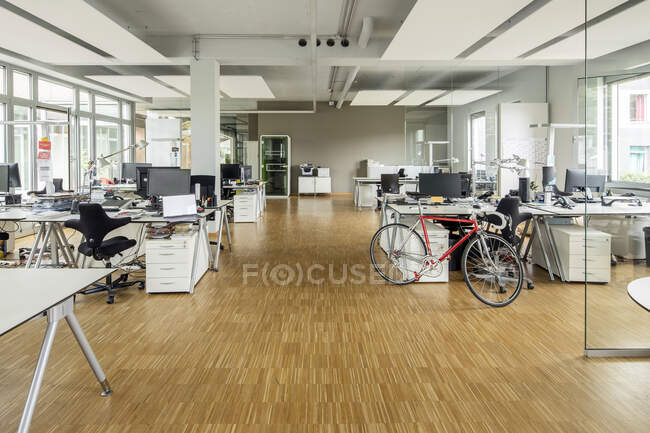 Bicycle at desk in office — Stock Photo