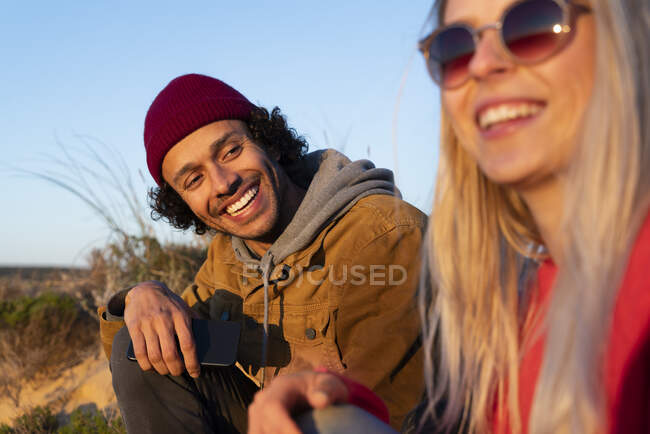 Young man looking at woman while sitting outdoors during sunset — Stock Photo