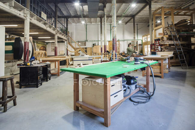 Colaboradores masculinos que operan maquinaria en taller de carpintería - foto de stock