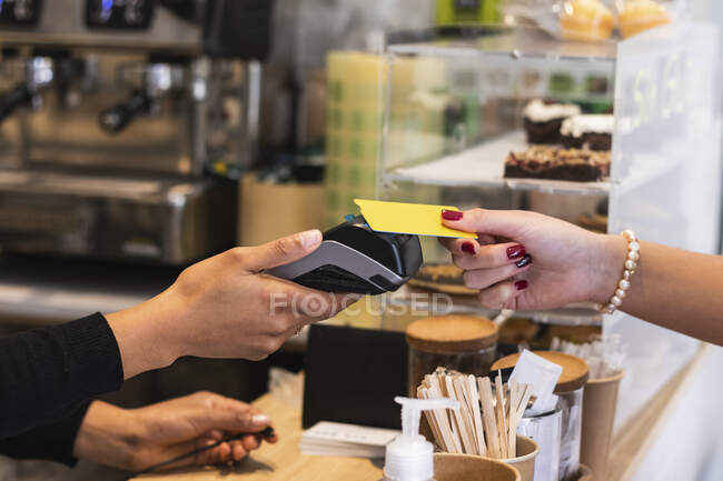 Woman paying through credit card at cafe — Stock Photo