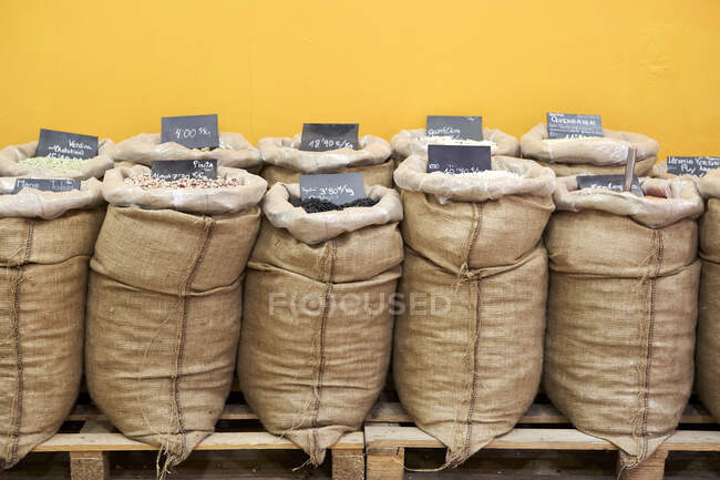 Variétés de céréales et de graines en sac en magasin au mur — Photo de stock