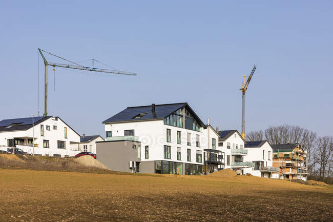 Allemagne, Baden-Wurttemberg, Waiblingen, banlieue moderne économe en énergie avec grues industrielles en arrière-plan — Photo de stock