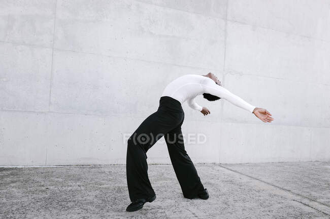 Dançarino masculino praticando dança urbana contra parede branca — Fotografia de Stock