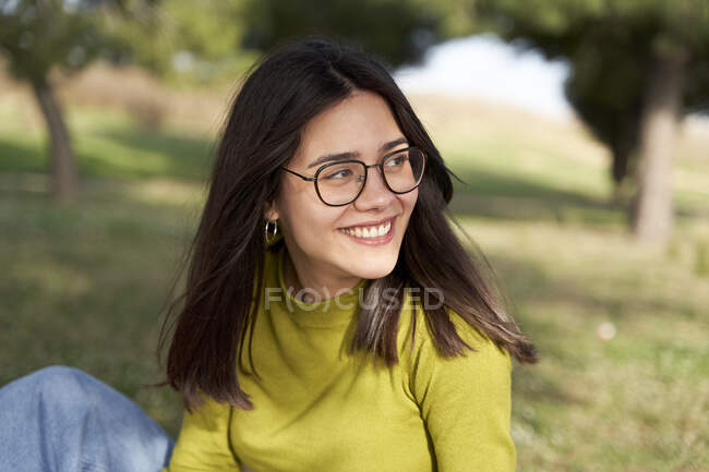 Усміхнена жінка з окулярами, озираючись. — стокове фото