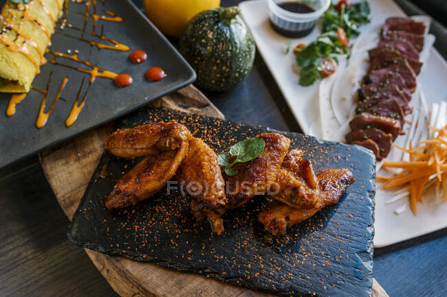 Allettanti ali di pollo e carne serviti nel ristorante — Foto stock