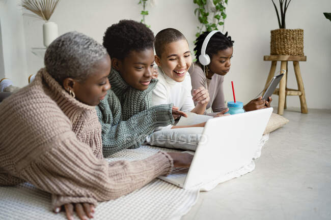 Glückliche Unternehmerinnen arbeiten, während sie vorne im Wohnzimmer liegen — Stockfoto