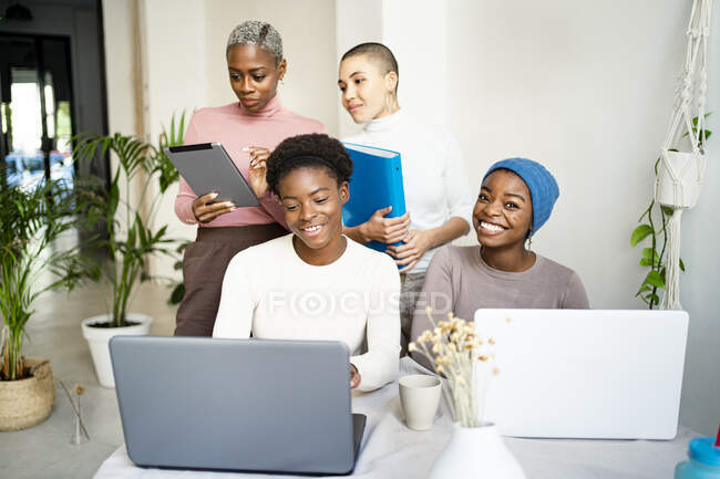 Glückliche Kolleginnen, die zu Hause am Laptop arbeiten — Stockfoto