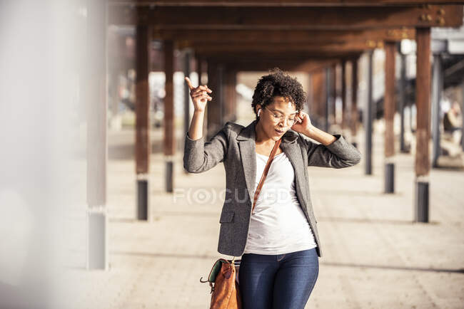 Mulher alegre dançando enquanto ouve música no caminho — Fotografia de Stock