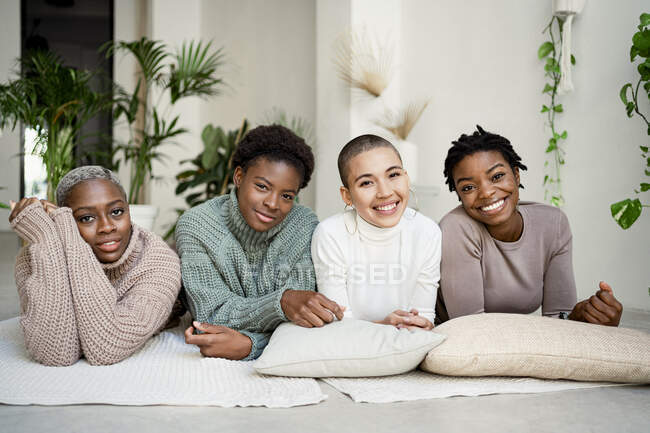 Lächelnde Freundinnen liegen zu Hause vorne — Stockfoto