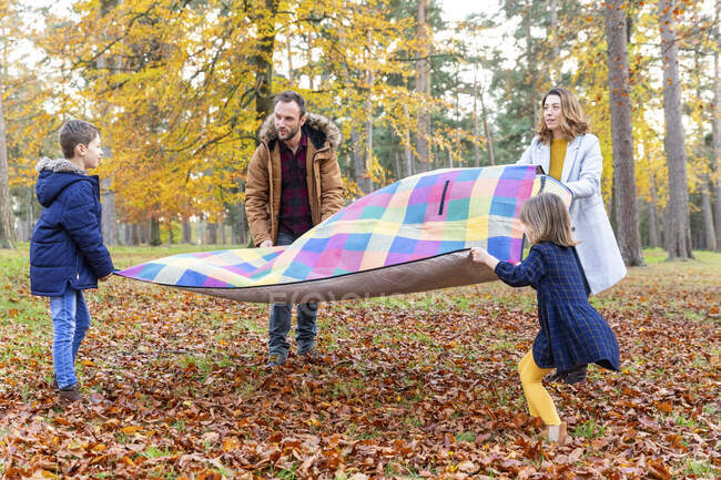 Famiglia fare pic-nic preparazione insieme mentre in piedi nella foresta — Foto stock
