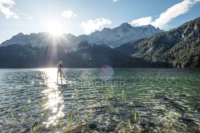 Germania, Baviera, Garmisch Partenkirchen, Giovane donna in piedi remare sul lago Eibsee — Foto stock