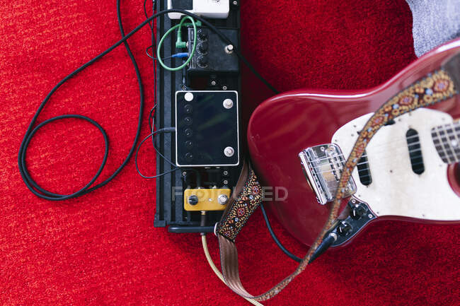 Музыкальный инструмент и гитара на ковре в студии — стоковое фото