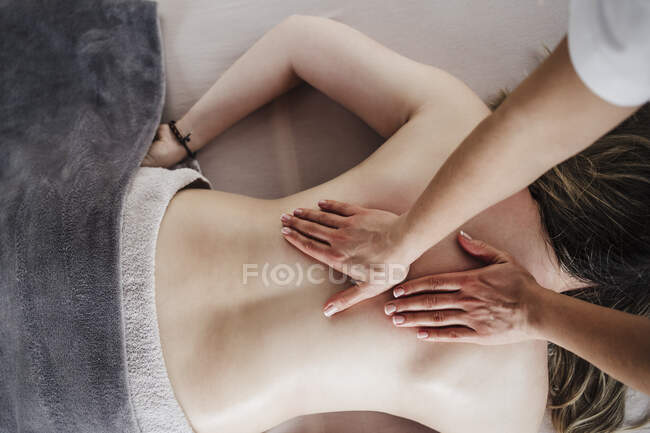 Жіночий фізіотерапевт робить масаж на спині пацієнта в лікарні. — стокове фото