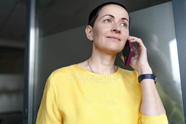 Bella professionista femminile che parla sul telefono cellulare in ufficio — Foto stock