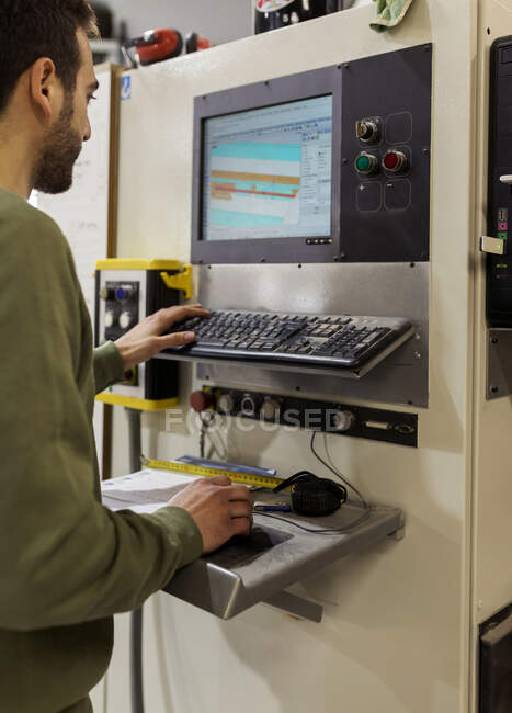 Young male carpenter operating CNC machine in workshop — Stock Photo