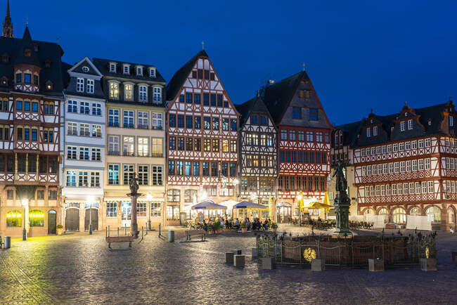Німеччина, Гессен, Франкфурт, Освітлена площа Ромерберга вночі з напівдерев'яними таунхаусами на задньому плані. — стокове фото