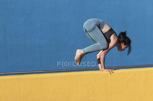 Woman doing handstand on retaining wall — Stock Photo