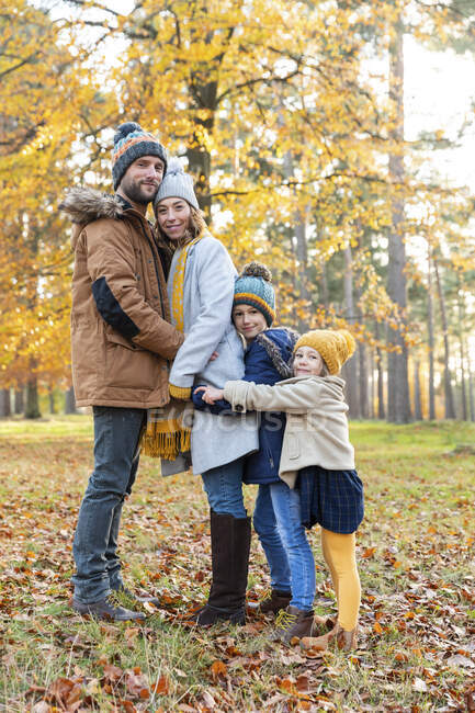 Family embracing each other while standing in forest during autumn — Stock Photo