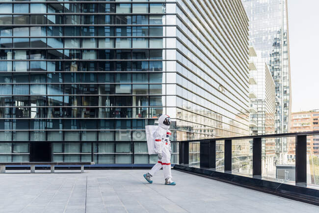 Male astronaut wearing space suit walking on rooftop — Stock Photo
