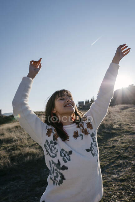 Donna felice con le braccia sollevate trascorrere il tempo libero in montagna — Foto stock