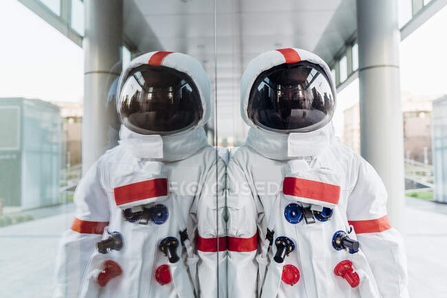 Мужчина-астронавт, опирающийся на стеклянную стену — стоковое фото